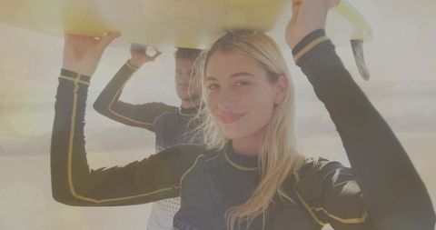 Friends Enjoying Surfing Adventure on Sandy Beach at Sunset