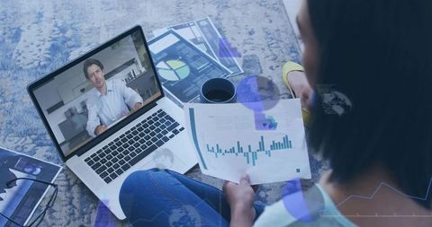 Woman reviewing financial charts during remote meeting on laptop, working from home