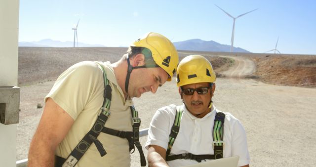 Engineers Collaborating at Wind Farm with Laptops Outdoors - Download Free Stock Images Pikwizard.com