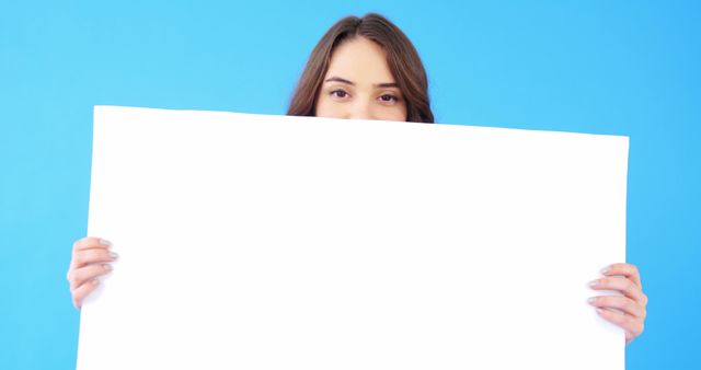 Young Woman Holding Blank White Sign on Blue Background - Download Free Stock Images Pikwizard.com