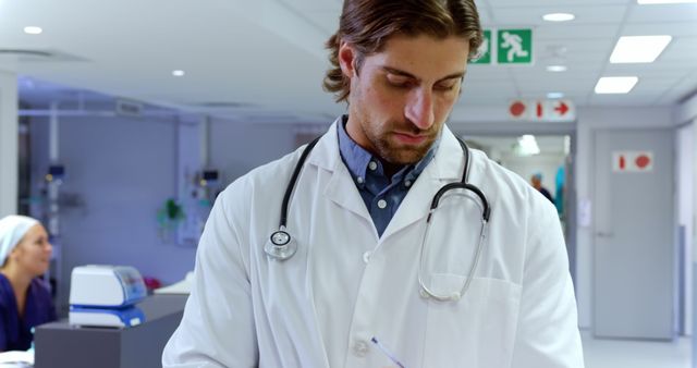 Male Doctor Reviewing Medical Notes in Hospital Corridor - Download Free Stock Images Pikwizard.com