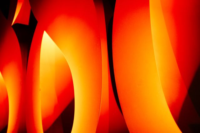 Abstract curved shapes in vibrant warm tones of orange and yellow. Great for use in backgrounds, modern art projects, digital interfaces, website design, and creative visuals aiming to evoke warmth and energy.