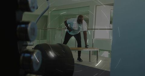 Performing One-Arm Dumbbell Row on Bench in Modern Gym with Towel and Focused Form