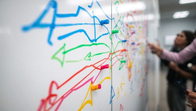 Showing colorful brainstorming arrows on whiteboard with magnetic marker caps