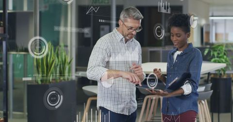 Diverse Professionals Analyzing Digital Data Charts in Modern Office Environment