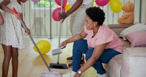 Family Teamwork Cleaning Up After a Colorful Birthday Party