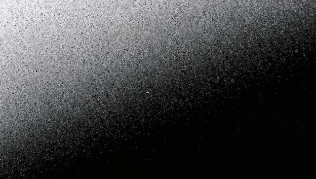 Diagonal granular gray gradient creating speckled noise texture for modern backgrounds