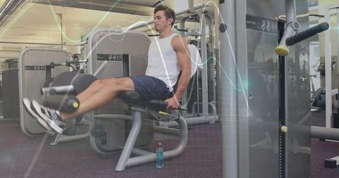 Athlete doing leg extension exercises in modern gym