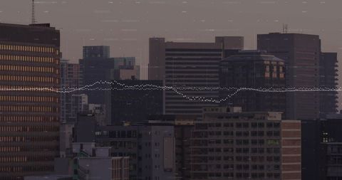 Dusk downtown skyline with high-rise towers and data waveform overlay for smart city visualization