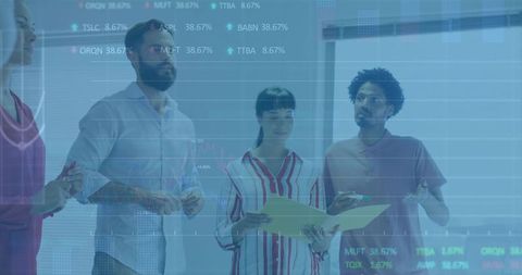 Diverse team analyzing projected financial charts on glass wall with tablet and folder
