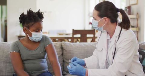 Female Doctor Giving Vaccine to Young Girl at Home Health Check