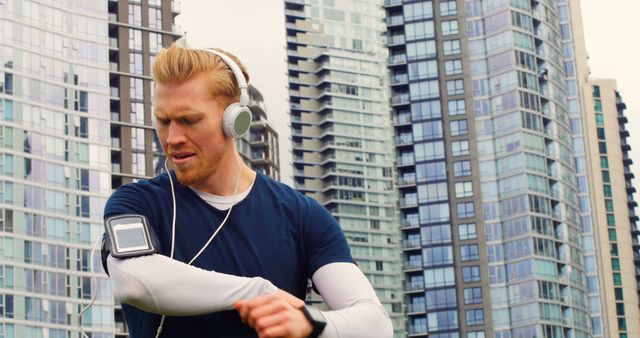 Fitness Enthusiast Adjusting Music Player During Outdoor Workout - Download Free Stock Images Pikwizard.com