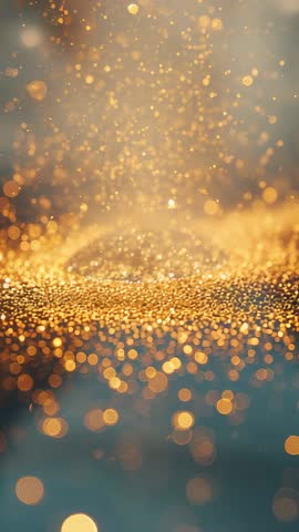 Vertical video of golden glitter lifting over textured surface with warm bokeh glow