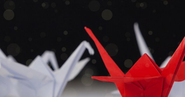 Showcase vibrant art of origami against dramatic background with glowing bokeh points. Ideal for  decoration, article about Japanese crafts and artistry, forum graphic invoking precision.