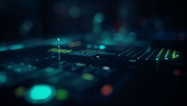 Illuminated dj mixer console in club booth night scene