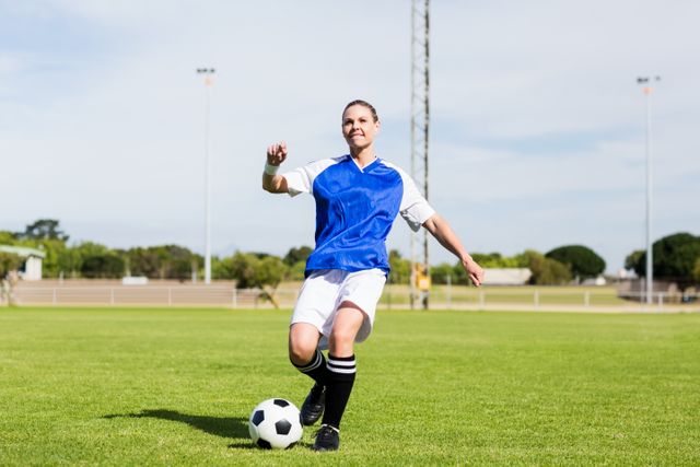 Female football player practicing soccer in a stadium