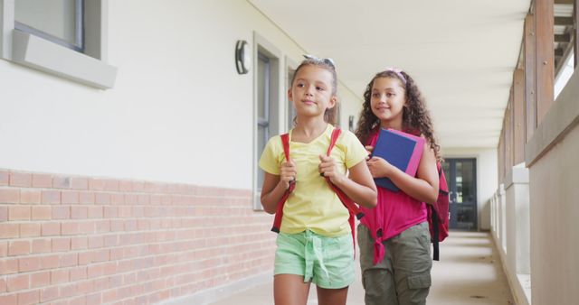 Smiling Schoolgirls Walking in Hallway with Backpacks and Books - Download Free Stock Images Pikwizard.com