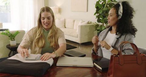 Diverse women unpacking garment continuing collaboration