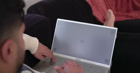 Indian man typing on laptop in cozy home lounge for remote work and casual productivity