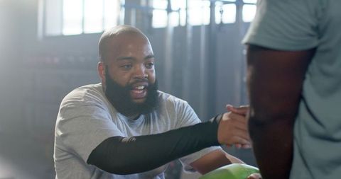 African american men passing medicine ball during functional fitness training in gym