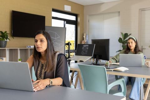 Indian women collaborating on architectural designs in modern coworking office