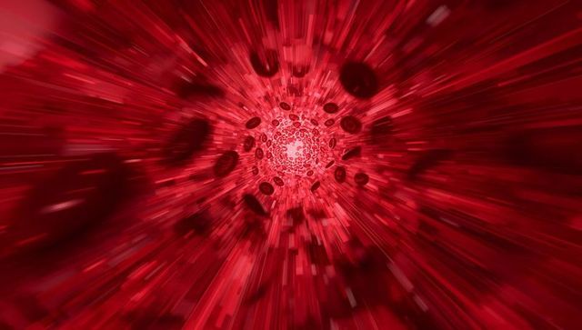 Red blood cells streaming through vessel toward glowing center with motion blur