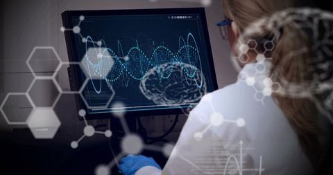 Female researcher analyzing brain data on monitor with hexagonal science overlay and neural waveform