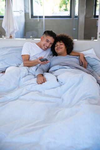 Relaxed Couple Enjoying Leisure Time in Minimalist Bedroom