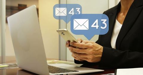 Professional Woman Handling Emails on Smartphone with Laptop