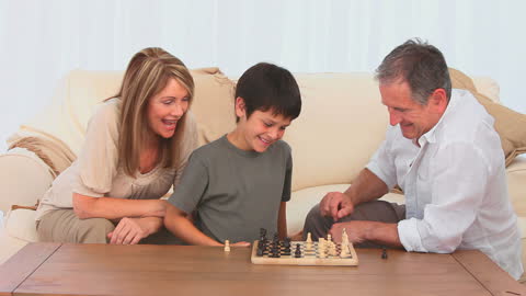 Grandfather and Grandson Enjoying Chess Game at Home