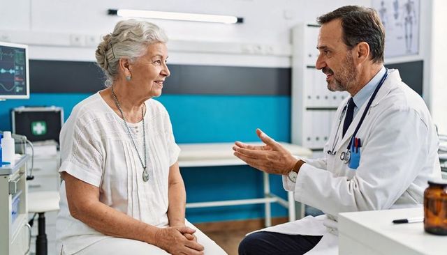 Compassionate doctor consulting senior patient in bright clinic, trusted healthcare visit