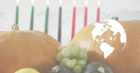 Autumn harvest still life with pumpkins, grapes, squash, candles and world map overlay