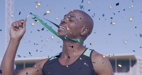 Joyful Athlete Celebrates Victory with Medal Amidst Confetti