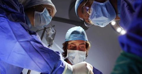 Surgical Team Performing Complex Operation with Focused Male Surgeon and Medical Staff