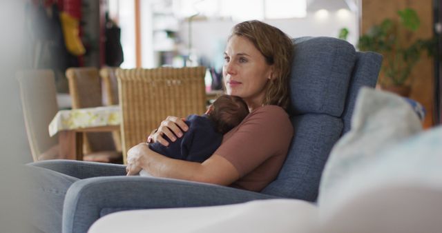 Image of caucasian mother sitting in armchair with newborn baby. motherhood, parental love and taking care of newborn baby concept digitally generated image.
