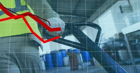 Warehouse worker pushing pallet jack with red decline graph overlay for logistics concept