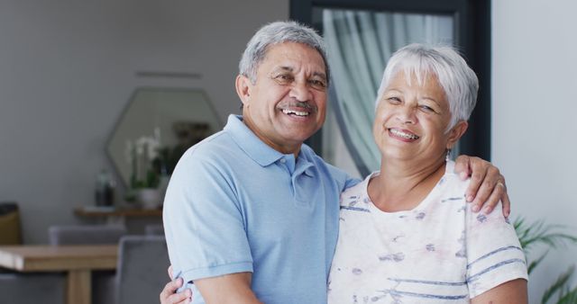 Portrait of happy senior biracial couple embracing. Spending quality time at home, retirement and lifestyle concept.