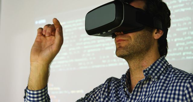 Man wearing virtual reality headset experiencing digital simulation with hand gesture. Ideal for technology, innovation, virtual experiences, and futuristic themes.