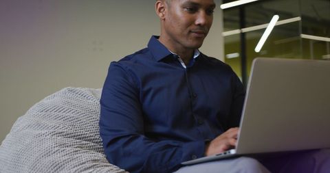 Focused Business Professional Working on Laptop in Modern Office