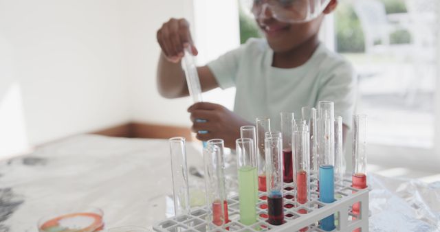 Child conducting chemistry experiment with colorful test tubes at home, emphasizing curiosity and learning in a safe environment. Use this image to highlight educational activities, STEM programs, or fun science projects for kids.