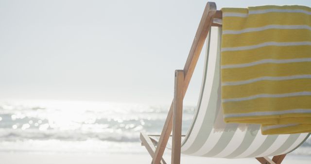Beach towel on deckchair on sunny sand beach facing the sea, copy space. Beauty in nature, vacations, summer and relaxation.