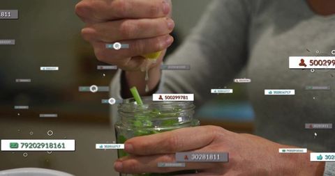 Squeezing lemon over mason jar with mint and floating data tags for tech-health concept