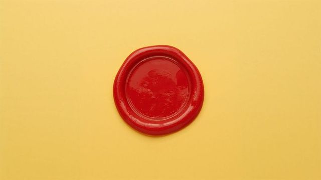 Red sealing wax seal on yellow paper background