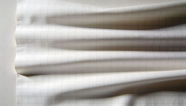 Draped grid-lined paper showing soft folds and subtle check pattern for design mockups