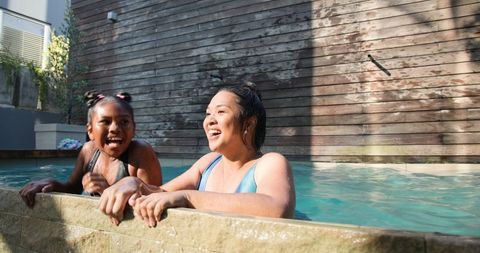 Diverse Mother and Daughter Pair Enjoying Quality Pool Time