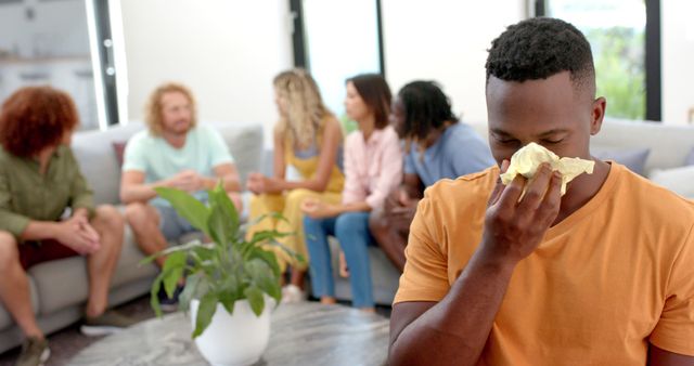 Emotional man crying and diverse friends talking in background during group therapy session. Mental health, therapy, support, communication, lifestyle and friendship.