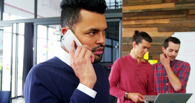 Businessman Talking on Smartphone in Modern Office with Colleagues - Download Free Stock Images Pikwizard.com