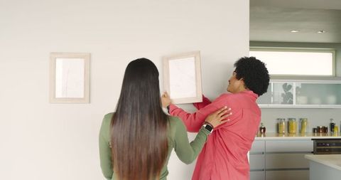 Couple collaborating on home decor with wooden frames