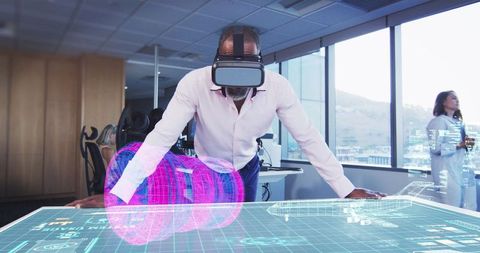 Innovative man using vr headset with holographic display in futuristic office