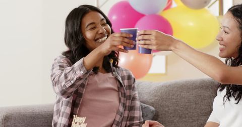 Women celebrating with drinks in a festive home atmosphere